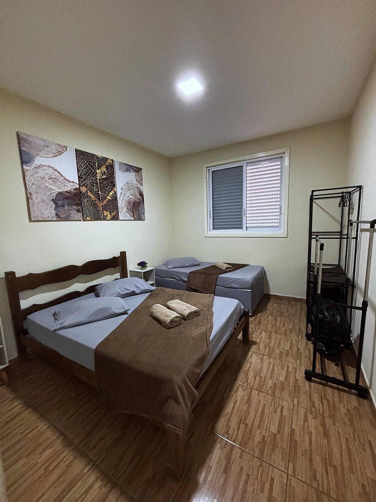 Quarto Rústico com cama de madeira maciça e quadros de arte natural